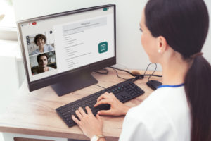 Doctor and patient using Coviu on computer screen