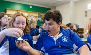 A girl and a boy in class open mouthed at science experiment